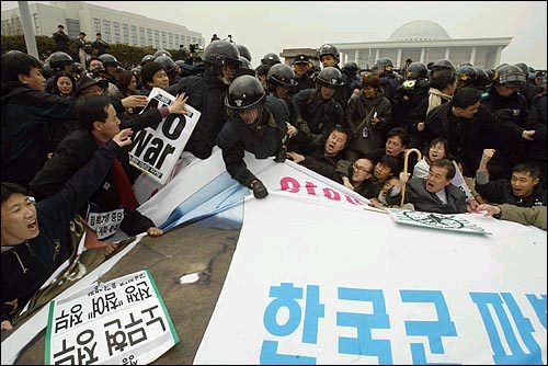 25일 오전 11시경 삼삼오오 흩어졌다가 국회 정문앞에 모여 농성을 벌이는 반전 시위대를 경찰이 강제진압하고 있다. 